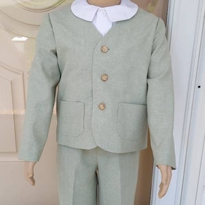May include: A light green suit with a white collared shirt. The suit has a button-up jacket with a pocket on each side and matching pants.