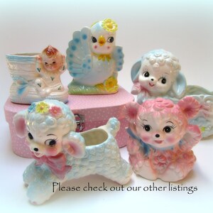 May include: A set of vintage ceramic planters featuring a blue bird, a baby in a shoe, a lamb, and a pink lamb. The planters are all in pastel colors and have a whimsical design.