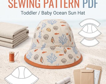 Puede incluir: Un sombrero de sol para bebé o niño pequeño en tela beige con un patrón repetitivo de coral azul, peces naranjas y conchas marrones, con un borde naranja. La imagen incluye el texto SEWING PATTERN PDF Toddler / Baby Ocean Sun Hat.
