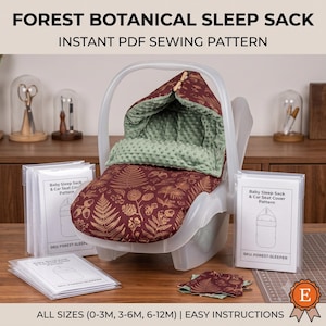 May include: A forest botanical sleep sack and car seat cover sewing pattern. The product is a dark red fabric with a gold fern and acorn print, featuring a sage green dimpled minky lining. Includes printed pattern documents in clear sleeves.