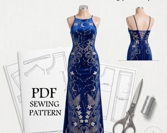 May include: The Celestial Velvet Gown - sewing pattern pdf. A blue velvet floor-length gown with silver celestial embroidery, thin straps, and a lace-up back. Includes printed paper pattern sheets, silver thread, and metal scissors for sewing.