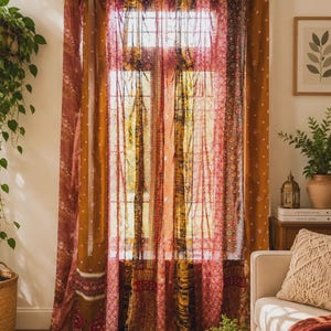 Pode incluir: Um conjunto de cortinas de comprimento total com um design de patchwork de painéis transparentes e opacos em tons de vermelho profundo, laranja queimado e dourado. O tecido apresenta padrões intrincados e está suspenso por presilhas.