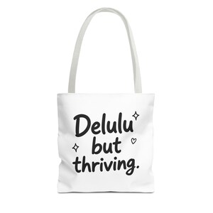 Delulu but thriving Tote Bag | Cute handwritten text, minimalist black script