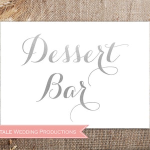 May include: A white sign with silver lettering that reads "Dessert Bar" with the text "FAIRYTALE WEDDING PRODUCTIONS" at the bottom.