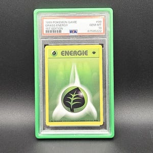 Könnte beinhalten: Eine 1999 Pokemon Game Grass Energy Sammelkarte, 1. Edition, bewertet mit PSA Gem Mt 10. Die Karte zeigt einen grünen Hintergrund mit einem zentralen Blattsymbol und dem Text ENERGIE. Sie ist in einer schützenden, klaren Kunststoffhülle eingefasst.