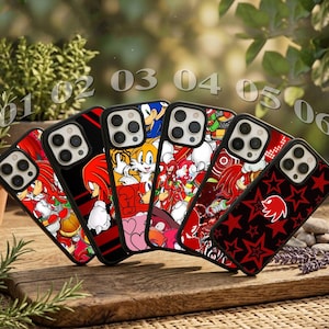 May include: Six smartphone cases arranged in a row, each featuring distinct graphic designs of Sonic the Hedgehog characters including Knuckles and Tails, with red, black, and white color schemes, and one case displaying a red star pattern.