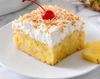 Pode incluir: Uma fatia quadrada de bolo de abacaxi amarelo coberta com chantilly branco, flocos de coco tostados e uma única cereja ao marrasquino vermelha brilhante. O texto "The Sugared Flour with Maya Callen" é visível no canto superior direito.