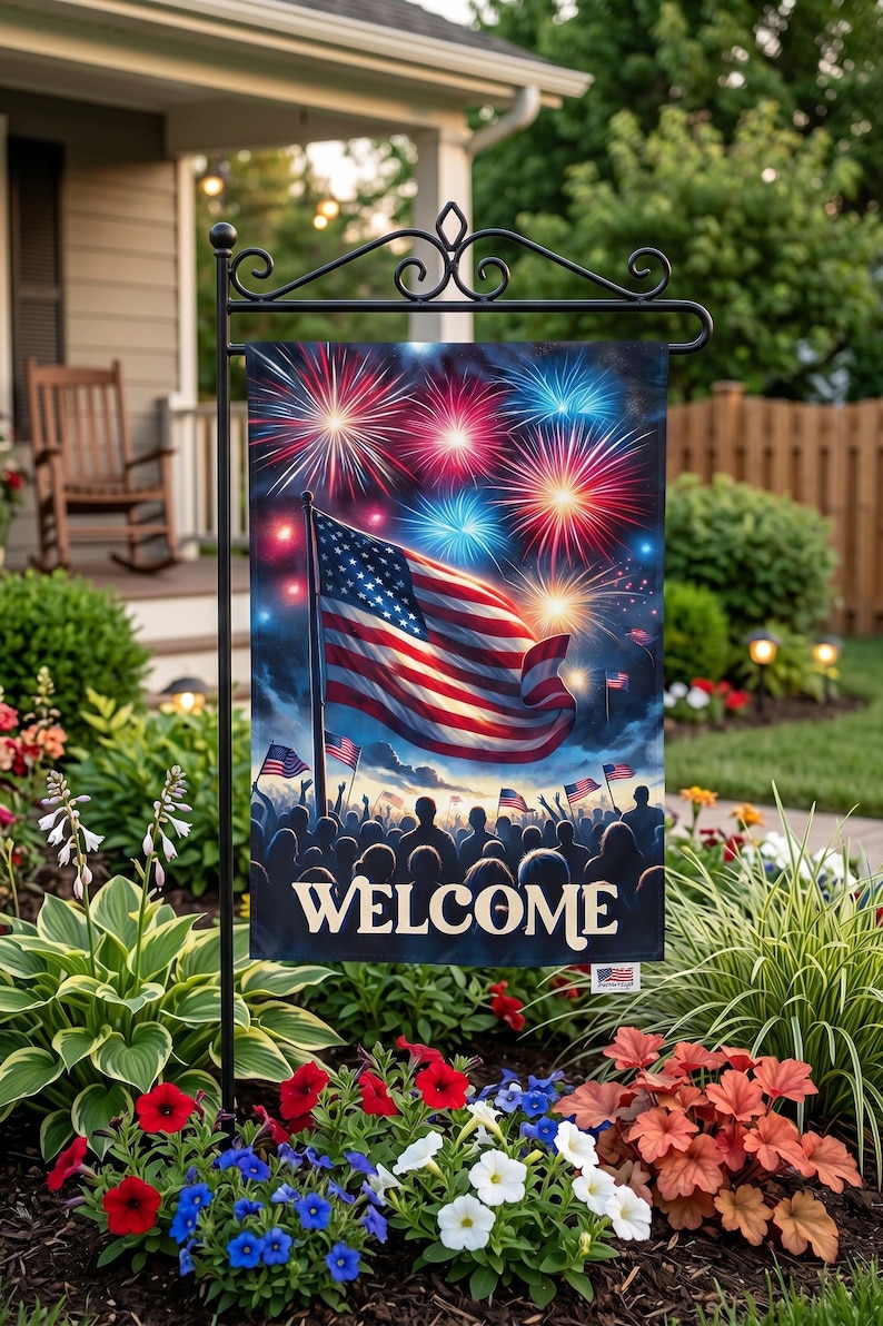A patriotic welcome sign featuring an American flag and fireworks is displayed in a garden setting with colorful flowers and greenery.