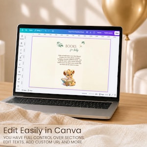 May include: A laptop screen displaying a digital invitation template with the text BOOKS for baby, featuring a lion cub illustration reading a book, surrounded by green leaf accents, all set within a Canva editing interface on a wooden surface.