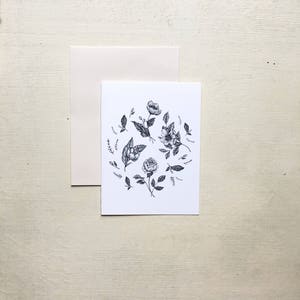 May include: A black and white illustration of a floral arrangement with various flowers and leaves. The flowers are arranged in a circle and are drawn in a realistic style.