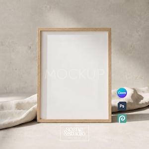 May include: A vertical rectangular picture frame with a light wood grain finish and a white mat board interior. The frame is positioned upright, featuring a clean, simple design suitable for displaying artwork or photographs in a home setting.