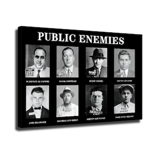 May include: A black rectangular wall art print titled PUBLIC ENEMIES featuring eight black and white mugshots of historical figures. Each portrait includes a name label and a booking number plate. The figures are arranged in two rows of four.