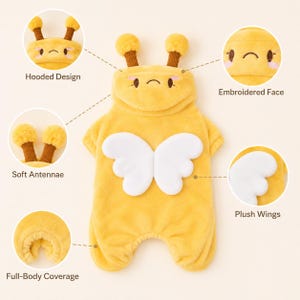 May include: A yellow plush pet costume featuring a hooded design with brown antennae, an embroidered face, white plush wings on the back, and full-body coverage. The garment includes text labels pointing to these specific features.