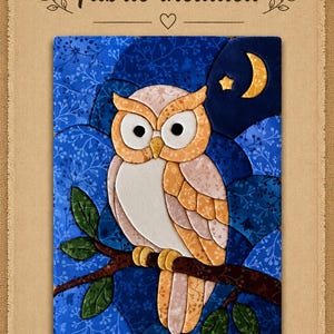 May include: A fabric wall hanging featuring a tan and white owl perched on a brown branch with green leaves against a dark blue floral background. A yellow crescent moon and star are in the upper right corner. The text Fabric included is at the top.