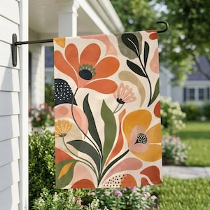 Könnte beinhalten: Eine rechteckige Gartenflagge mit einem botanischen Muster aus großen, stilisierten Blumen in Orange-, Gelb- und sanften Rosatönen. Das Design umfasst dunkelgrüne und olivfarbene Blätter, schwarze Punkte und einen cremefarbenen Hintergrund.