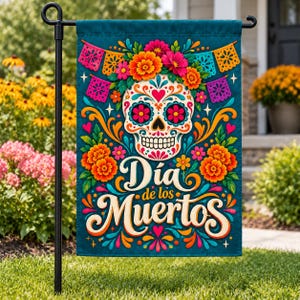 May include: A rectangular garden flag featuring a central white sugar skull decorated with colorful floral patterns, surrounded by orange marigolds and vibrant papel picado banners. The text "Día de los Muertos" is printed in a large, stylized font.