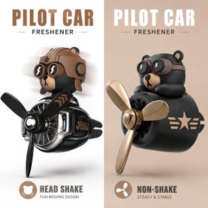 Pode incluir: Dois aromatizadores de carro Pilot Car com um urso preto usando óculos de aviador e capacete. A unidade esquerda tem uma hélice preta e cabeça oscilante, enquanto a direita possui uma hélice dourada e um design estável e fixo.
