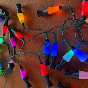 May include: A white ceramic mug with a black handle and the text "But First, Coffee" in a bold, black font. The mug is set against a blurred background, highlighting its clean design.