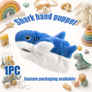 May include: A plush shark hand puppet with blue and white fur, featuring black and white eyes and a wide mouth. The image includes the text Shark hand puppet, 1PC, and Custom packaging available, surrounded by various wooden and plush toys.
