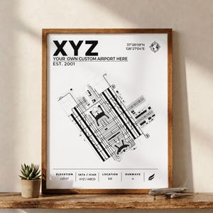 May include: A framed wall art print featuring a black and white technical diagram of an airport layout. The text reads XYZ, YOUR OWN CUSTOM AIRPORT HERE, EST. 2001, 37°28'09"N 126°27'04"E, ELEVATION +23 FT, IATA/ICAO XYZ/ABCD, LOCATION KR, and RUNWAYS 4.