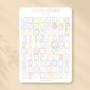 Op de afbeelding: Een rechthoekig stickervel met de tekst alphabet stickers bovenaan en Myjournalpages onderaan. Het vel bevat meerdere rijen met gekleurde, omlijnde hoofdletters en kleine letters van het alfabet in vierkante vakjes.