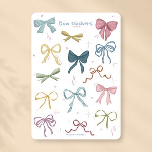 Op de afbeelding: Een stickervel met diverse geïllustreerde strikken in tinten blauw, roze, geel, groen en bruin. De tekst "Bow stickers" staat bovenaan en "myjournalpages" onderaan. De strikken hebben verschillende vormen en texturen.
