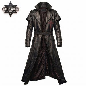 May include: A long black leather trench coat featuring a wide collar, a belted waist, and adjustable buckled cuffs. The coat displays a dark red cross emblem on the left chest and includes a dark patterned interior lining visible at the front.
