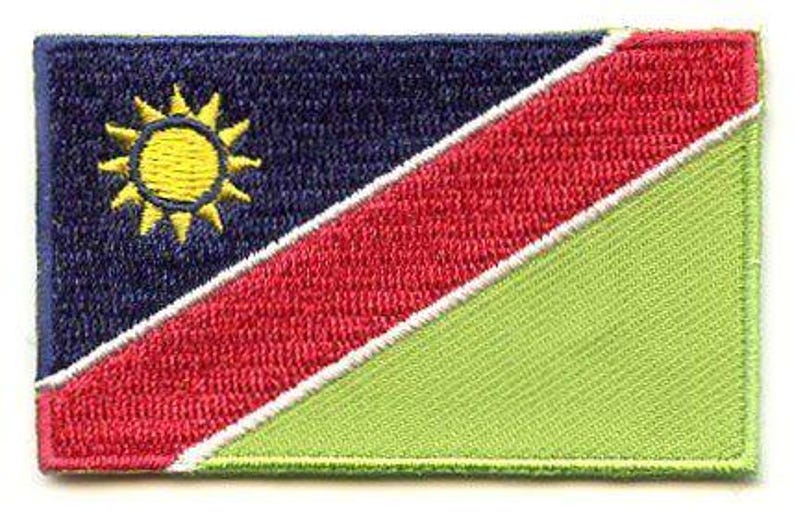 Namibia flag patch with blue, red, and green diagonal stripes, golden sun, and white borders, size 6.5 x 4 cm.