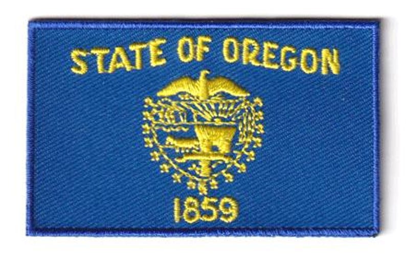 Oregon flag patch, 6.5 x 4 cm, blue with yellow emblem and text.