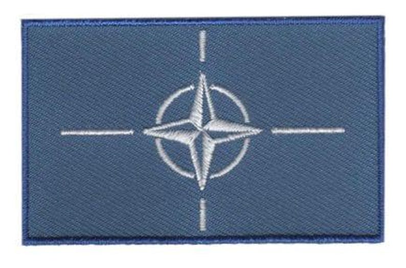 NATO flag patch with blue field and white compass rose emblem, 6.5 x 4 cm.