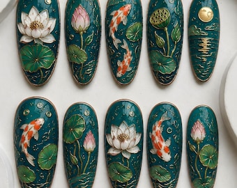 May include: A set of ten almond-shaped press-on nails featuring a deep teal background with raised gold-lined designs of white lotus flowers, pink lotus buds, green lily pads, orange and white koi fish, and a golden moon over water.