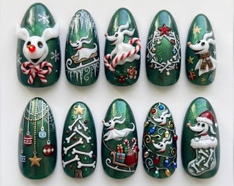 May include: A set of ten almond-shaped press-on nails featuring a dark green shimmer base with hand-painted and 3D sculpted designs of the character Zero from The Nightmare Before Christmas, including candy canes, bones, and holiday ornaments.