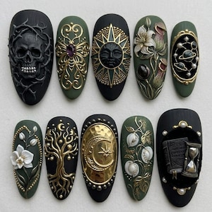 May include: A set of ten press-on nails featuring matte black and olive green bases with 3D embellishments including a skull, gold filigree, a sun face, pitcher plants, planets, white flowers, a tree, a crescent moon, and a book with an hourglass.