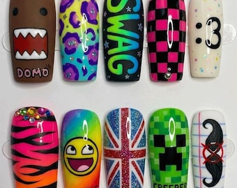May include: A set of ten press-on nails featuring diverse designs including a brown Domo character, neon leopard print, the word SWAG, pink and black checkers, a :3 emoticon, tiger stripes, a yellow smiley face, a Union Jack, a green Creeper, and a mustache.