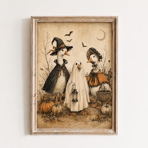 May include: A framed wall art print featuring three ducks in Halloween costumes. One duck wears a black witch hat and cape, one is dressed as a ghost holding a lantern, and one wears a bonnet and orange shawl with a basket. Pumpkins and bats are visible.