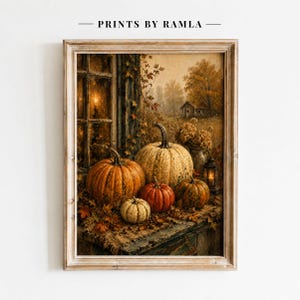 May include: A framed wall art print titled PRINTS BY RAMLA featuring an autumn scene with multiple pumpkins of varying sizes and colors resting on a wooden surface near a window, a lit lantern, and a distant house in a rural landscape.