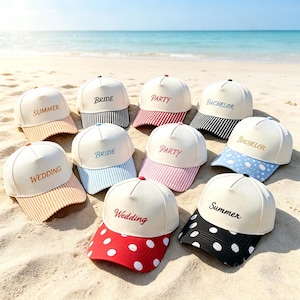 May include: A collection of ten baseball caps with white crowns and various colored brims featuring stripes or polka dots. Each cap displays embroidered text including Summer, Bride, Party, Bachelor, or Wedding in different fonts and colors.