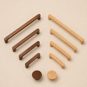 May include: A collection of wooden cabinet hardware including four dark brown walnut bar pulls, four light tan oak bar pulls, one dark brown circular knob, and one light tan circular knob, all arranged in a symmetrical V-shaped pattern.