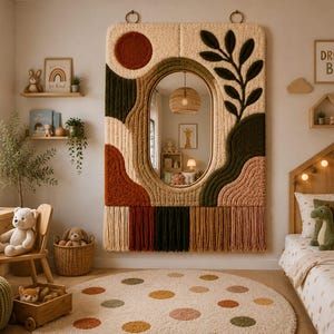May include: A large rectangular wall mirror featuring a thick, textured, tufted fiber frame in cream, olive green, rust, and tan. The frame includes abstract shapes, a circular sun motif, and a leafy branch design, finished with long fringe.