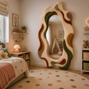 May include: A full-length floor mirror featuring an irregular, wavy frame covered in a textured, tufted material. The frame displays a color palette of cream, olive green, and burnt orange in flowing, organic shapes surrounding the central glass.