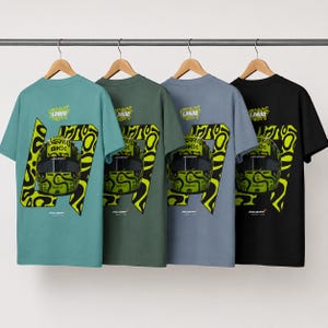 May include: Four short-sleeve t-shirts in teal, olive green, slate blue, and black hanging on hangers. Each shirt features a graphic of a yellow and black racing helmet, the number 47, the text LANDO, and the McLaren logo on the back.