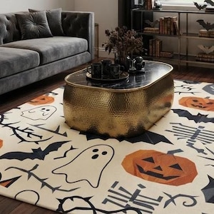 May include: A rectangular area rug featuring a cream-colored background with a repeating pattern of orange jack-o'-lanterns, black bats, white ghosts, and dark skeletal figures, designed with a flat-weave texture for indoor floor coverage.