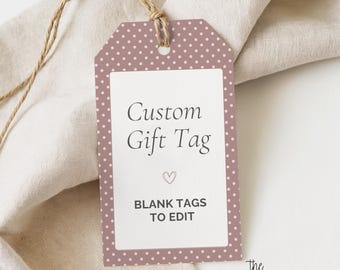 Puede incluir: Una etiqueta de regalo rectangular con fondo rosa empolvado, estampado de lunares blancos y un rectángulo blanco central. El texto dice Custom Gift Tag, un pequeño icono de corazón y BLANK TAGS TO EDIT. Tiene un cordel marrón en la parte superior.