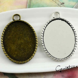 Puede incluir: Dos bandejas ovaladas de metal para colgantes con un borde de cuerda. Una bandeja es plateada y la otra es de bronce.