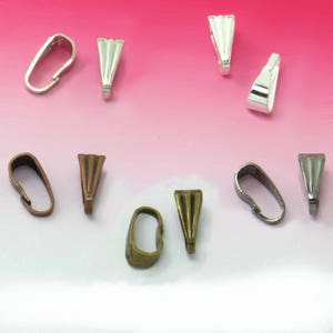 Op de afbeelding: Assortiment van zilveren, bronzen en koperkleurige metalen hangerbedels. De bedels zijn in verschillende vormen en maten.