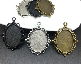 May include: Five oval-shaped pendant trays with a decorative border. The trays are in silver, black, and bronze.