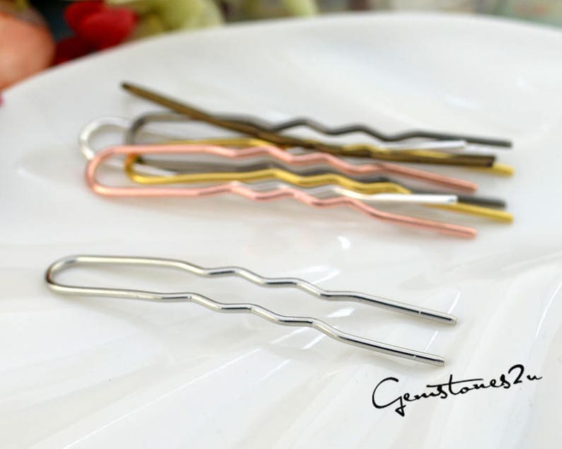 May include: A set of five wavy hair pins in silver, gold, rose gold, and black. The pins are arranged on a white surface.