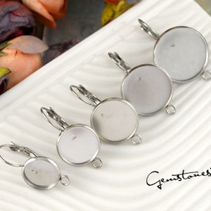 May include: Four silver earring settings with round bezels of different sizes. The bezels are designed to hold cabochons or other flat-backed stones.