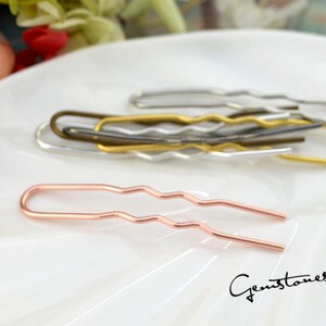 May include: A set of wavy hair pins in gold, silver, and rose gold. The pins are made of metal and have a wavy design. They are perfect for holding hair in place.