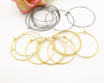 May include: A set of gold and silver hoop earrings. The gold hoops are stacked on top of each other, while the silver hoops are arranged in a circle.